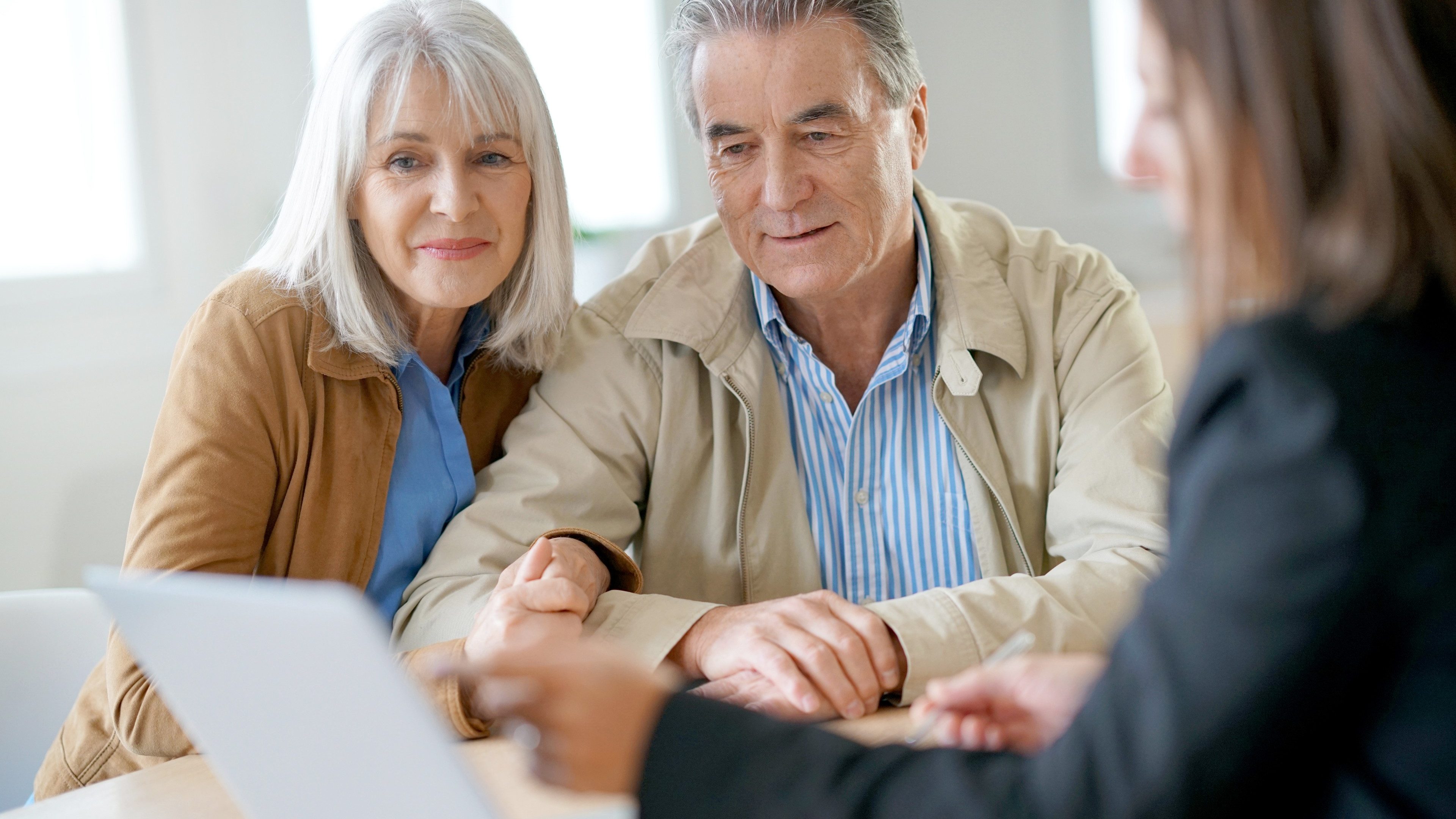 Senior couple meeting financial adviser for investment                