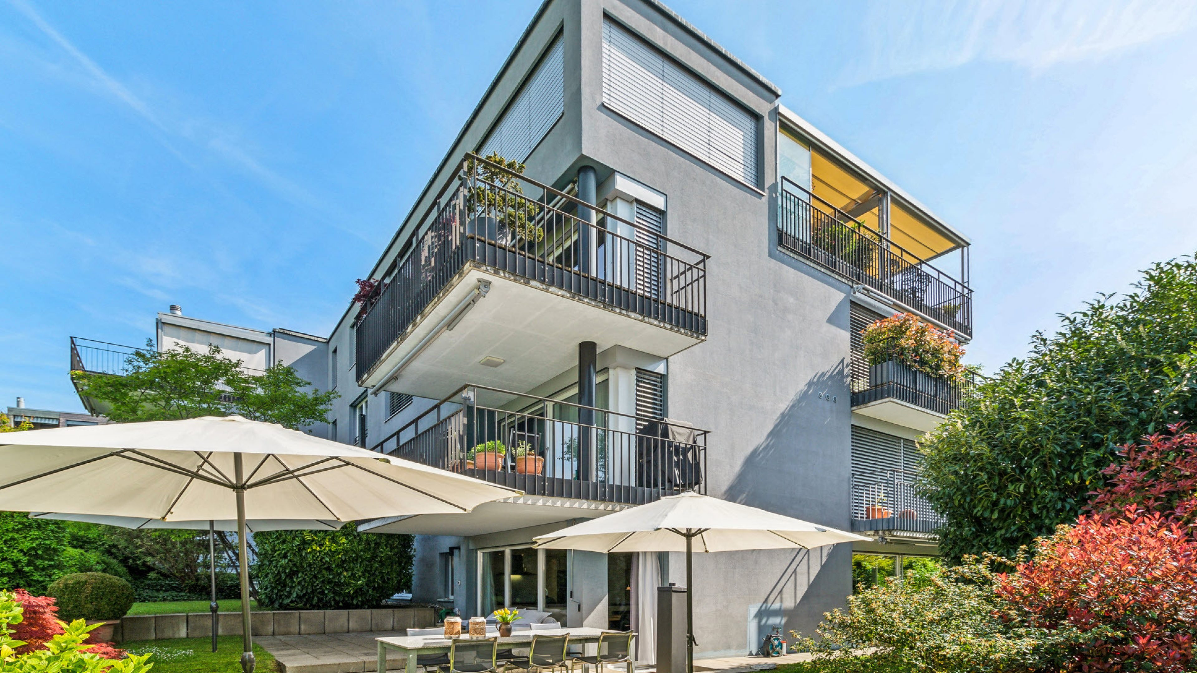 Immeuble locatif lumineux avec jardin et terrasse avec parasols