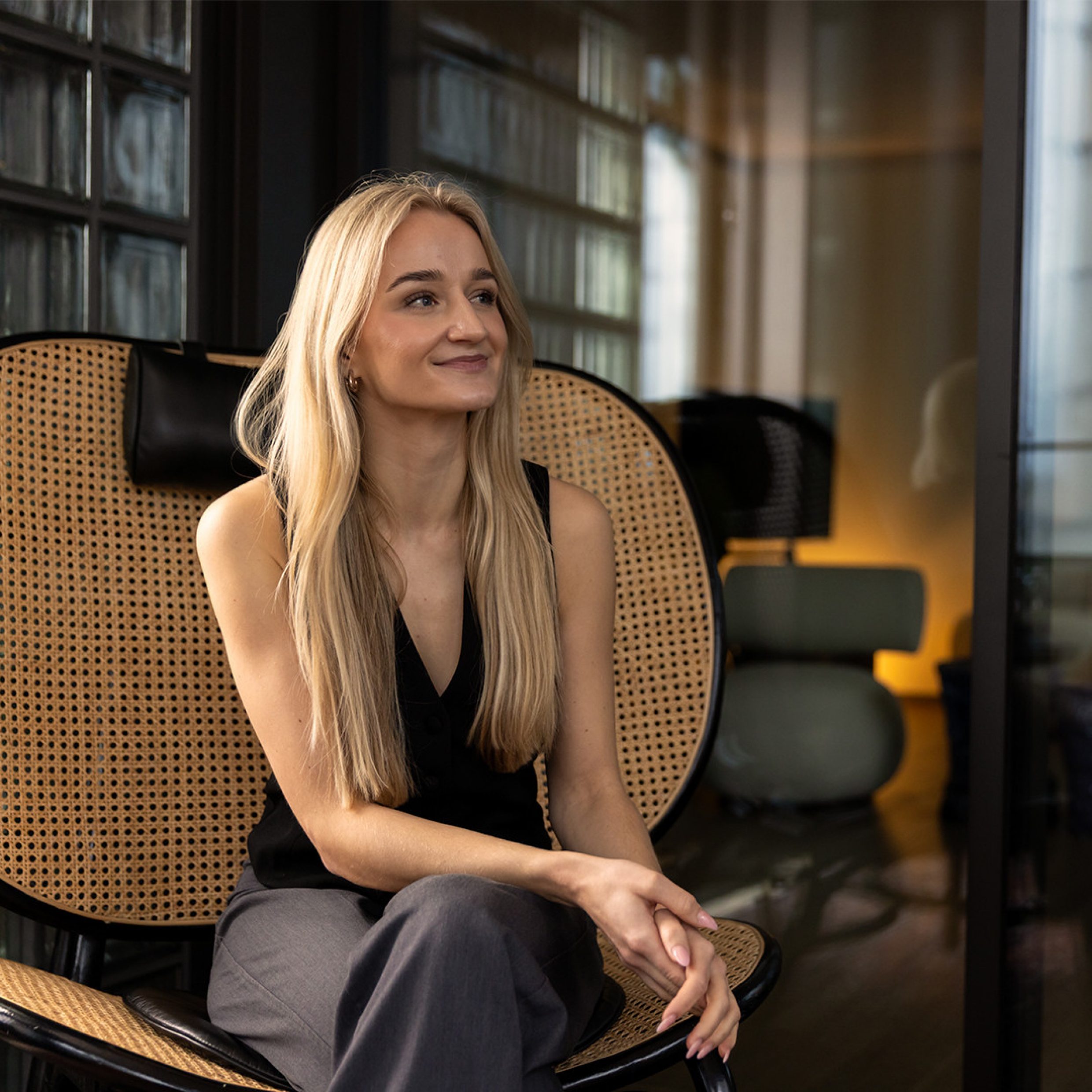 Laura Matter est assise dans un fauteuil en rotin.