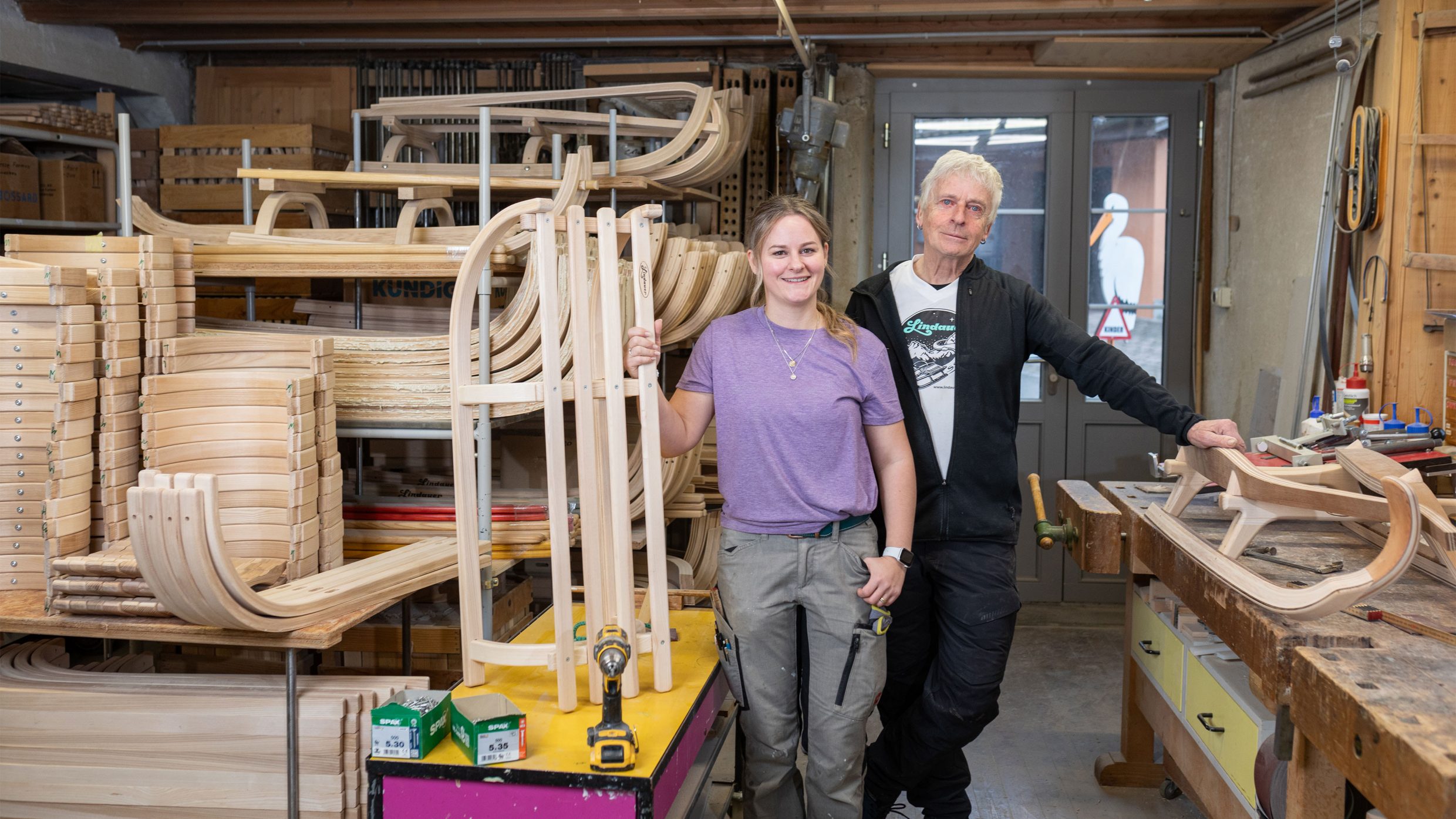 Photographie d’un homme et d’une femme debout dans un atelier de traîneau