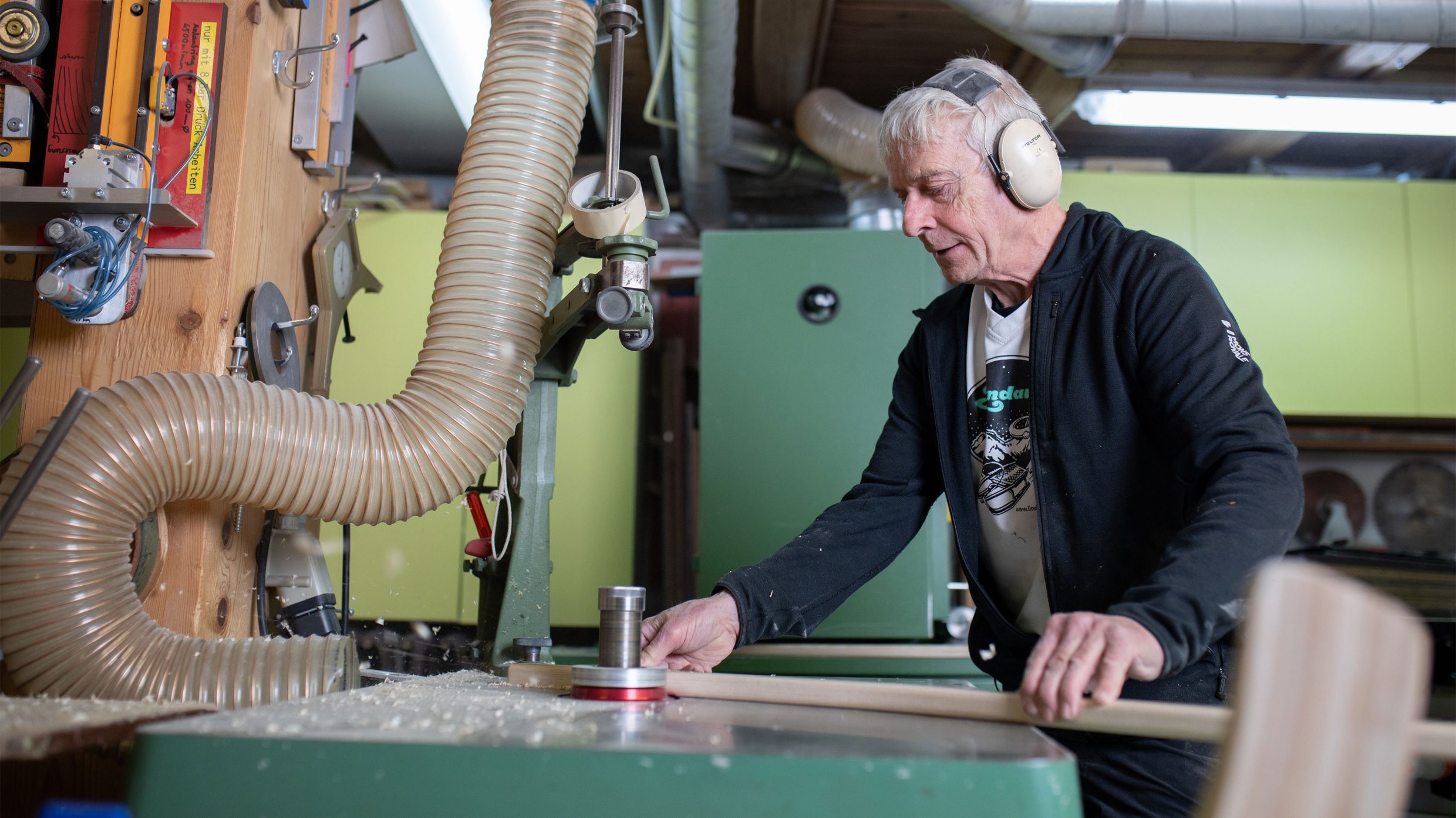 Photographie Homme travaillant du bois sur une machine dans un atelier