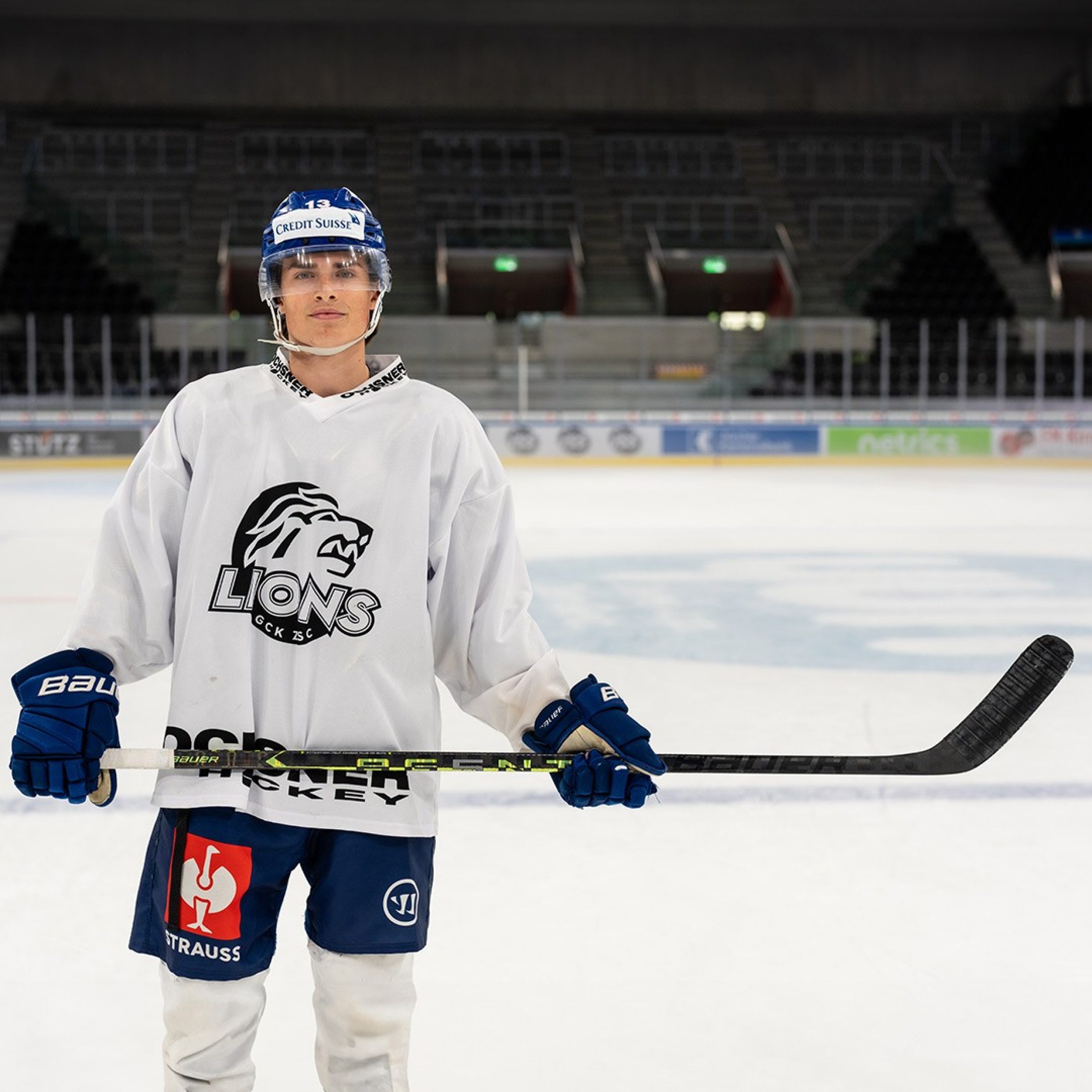 Jeune homme en tenue de hockey sur glace sur la patinoire