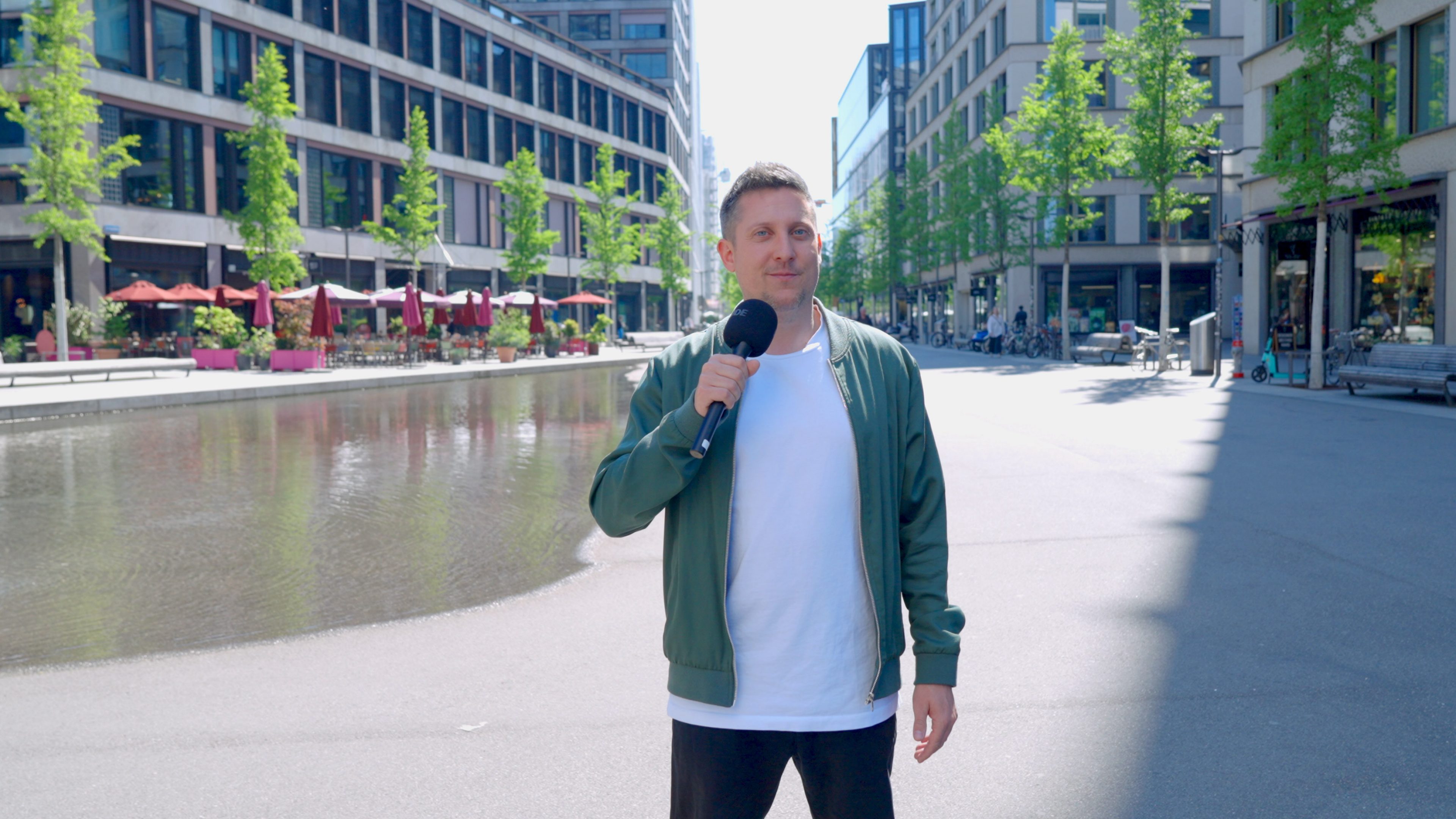 Marin Good steht mit dem Mikrofon in der Europaallee.