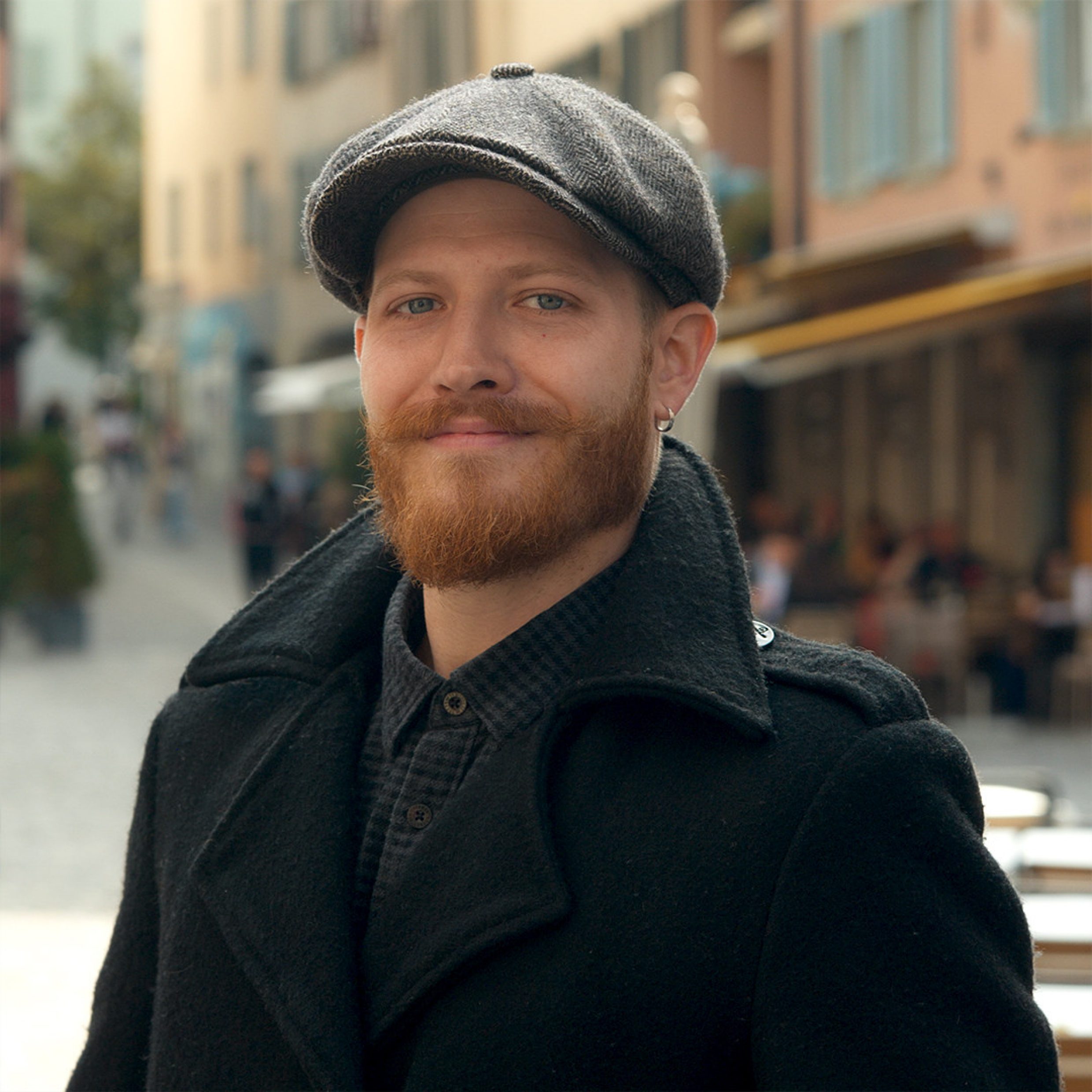 Portrait d’un homme; en arrière-plan, on voit la vieille ville de Zurich.