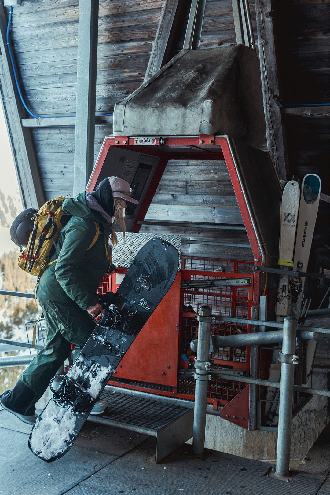 Une femme avec un snowboard monte dans le téléphérique Chäppeliberg-Spilau.