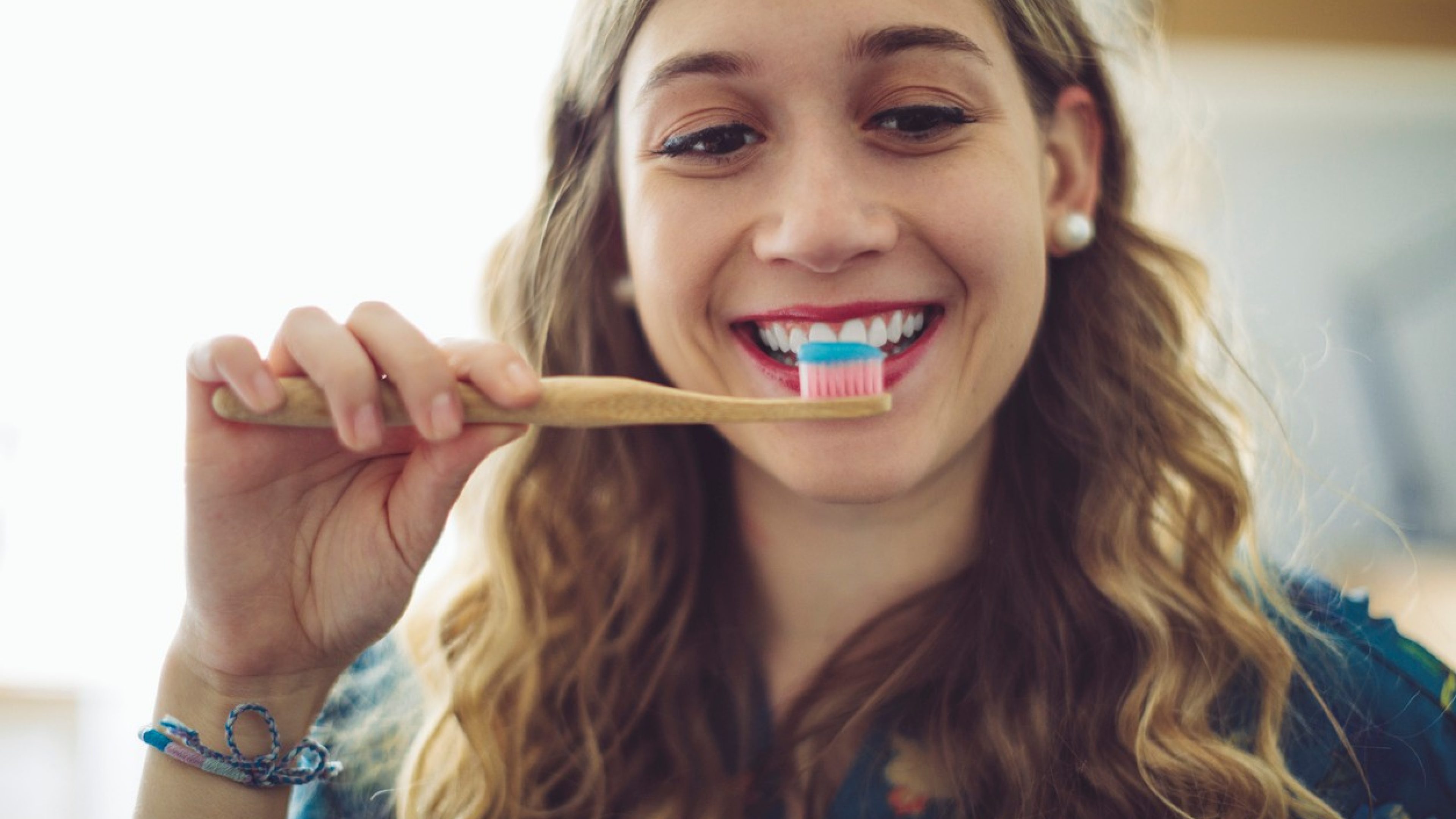 At home -  young woman brushing her teeth