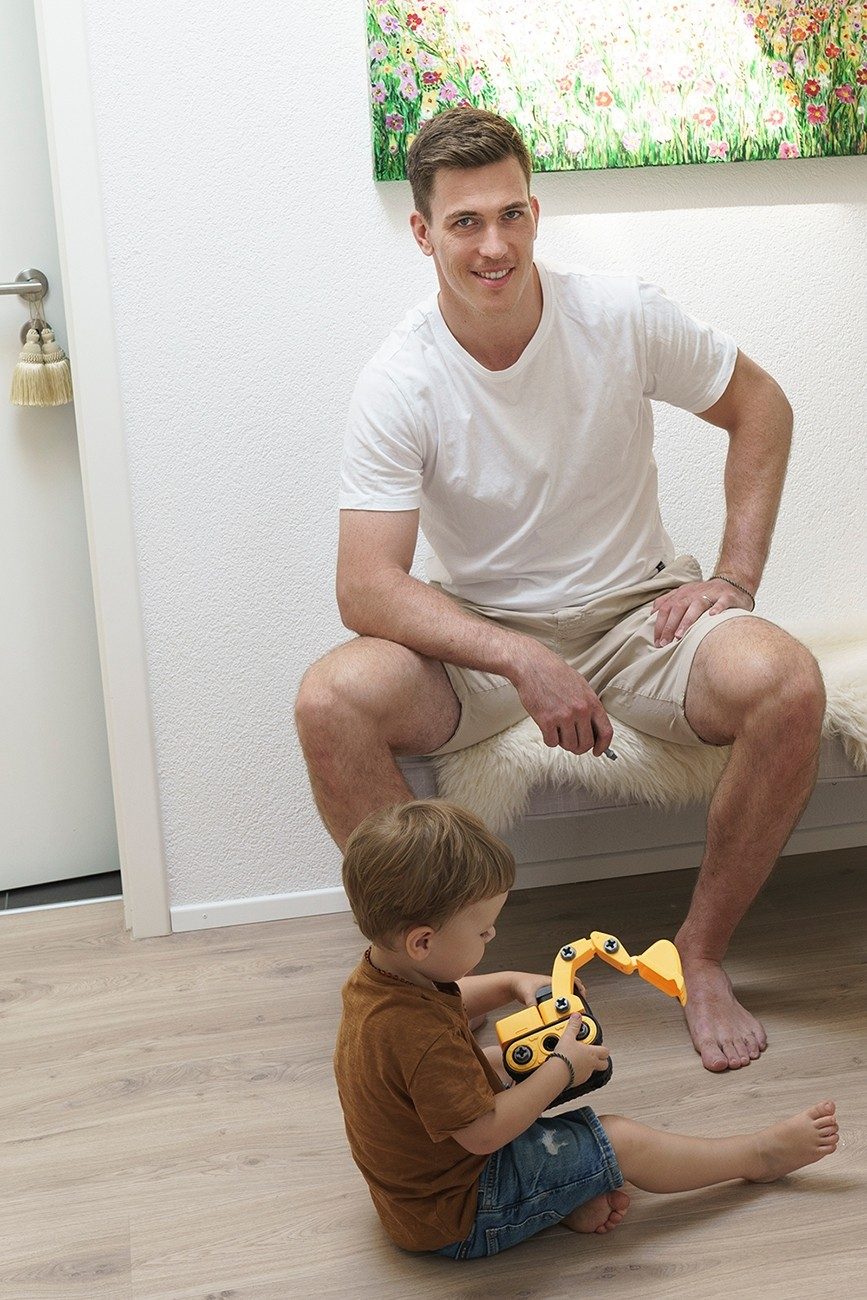 Un padre e il figlio giocano con un mini escavatore.
