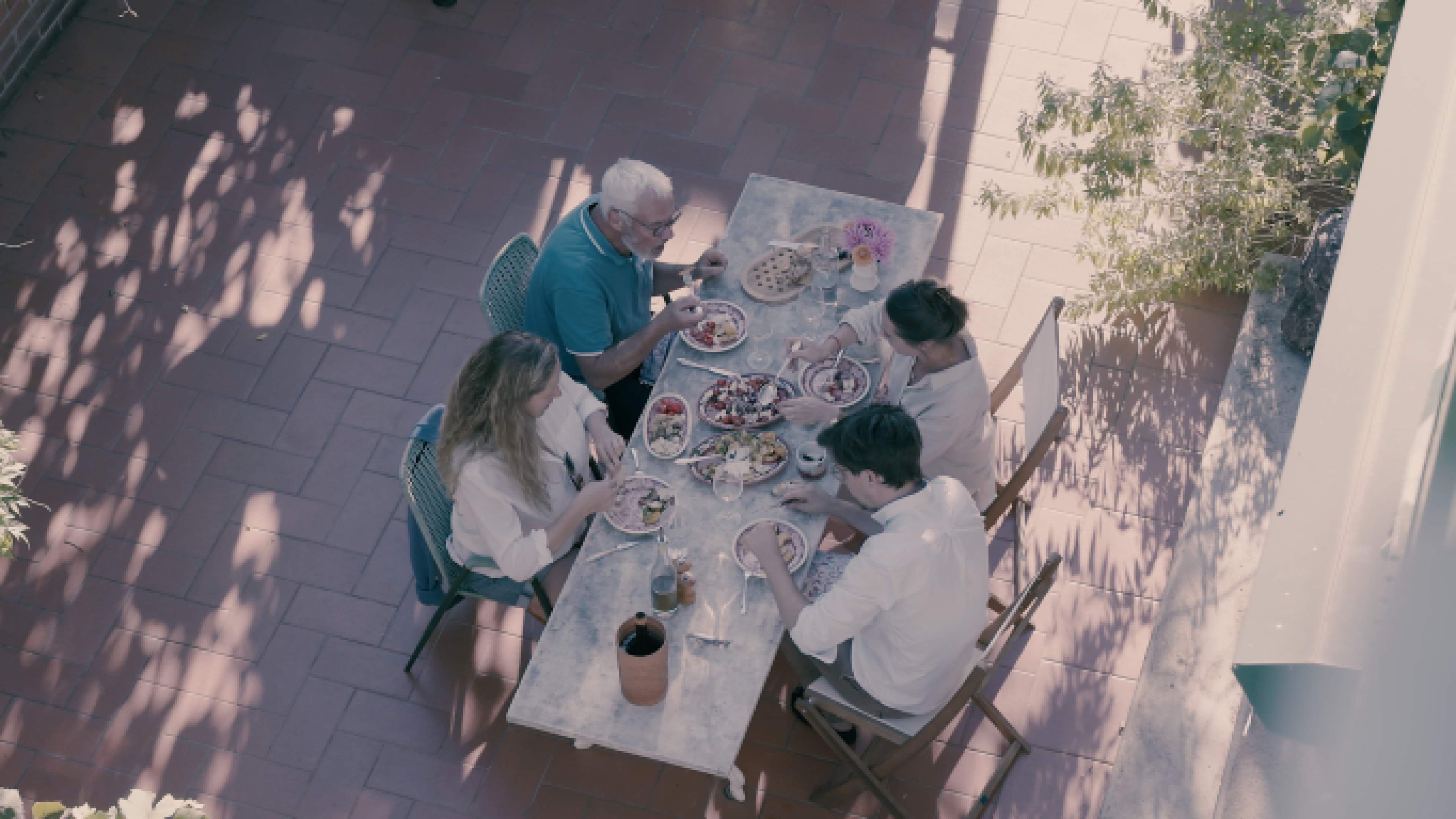 Quattro persone a tavola su un terrazzo.