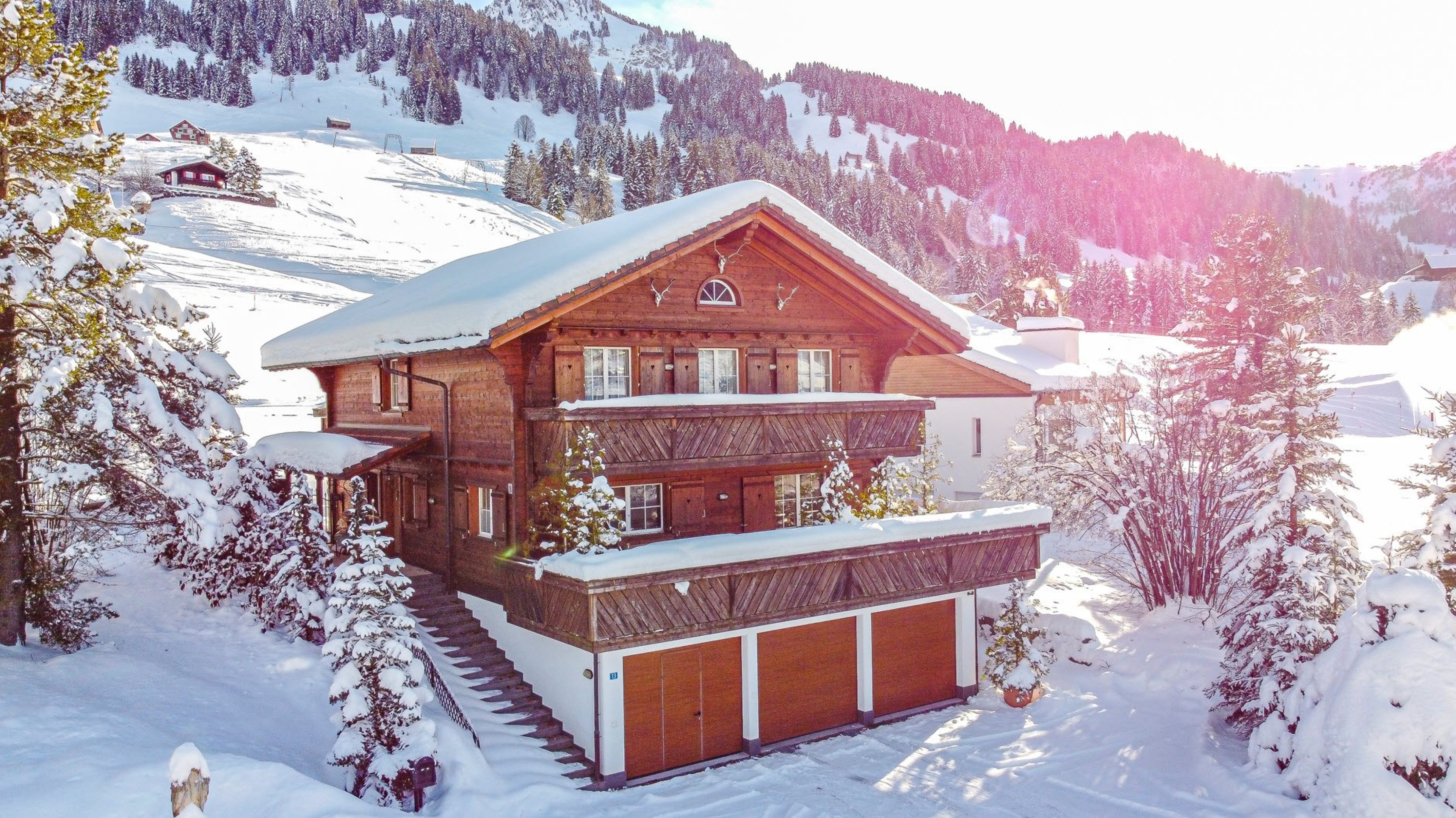 Grande chalet in legno in montagna. È inverno e c’è molta neve.