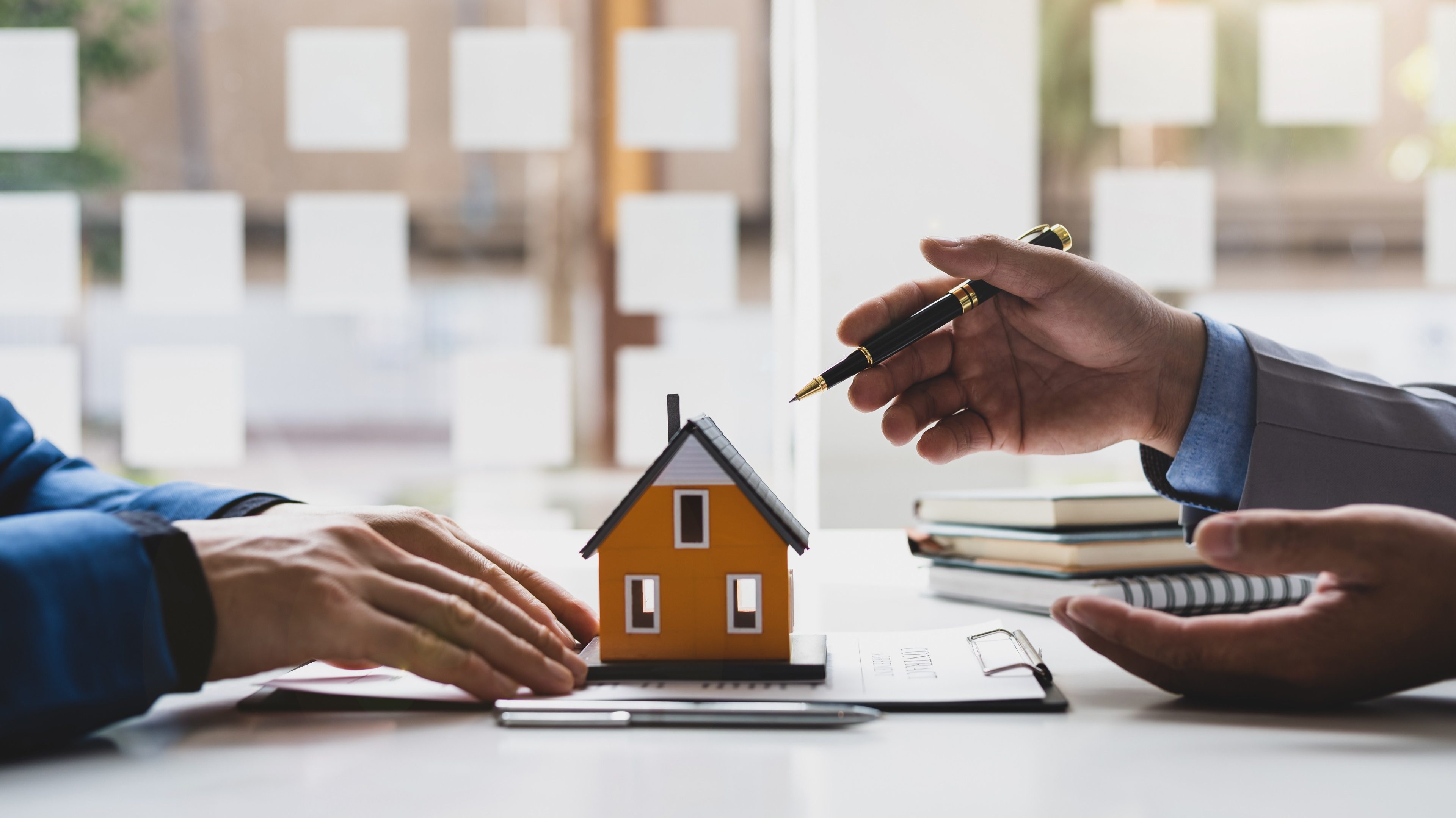 Real estate agent is discussing and explaining the terms of the home purchase contract. Businessman signing a contract agreement, mortgage, rent, lease, home insurance.