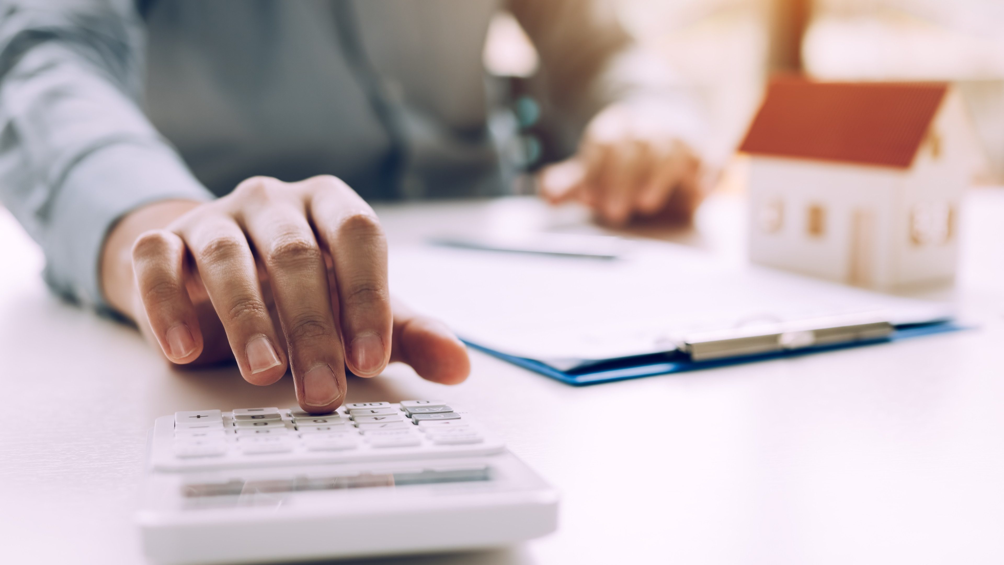 Close up of finger businessman using calculator calculate budget about house contract mortgage in the office room.