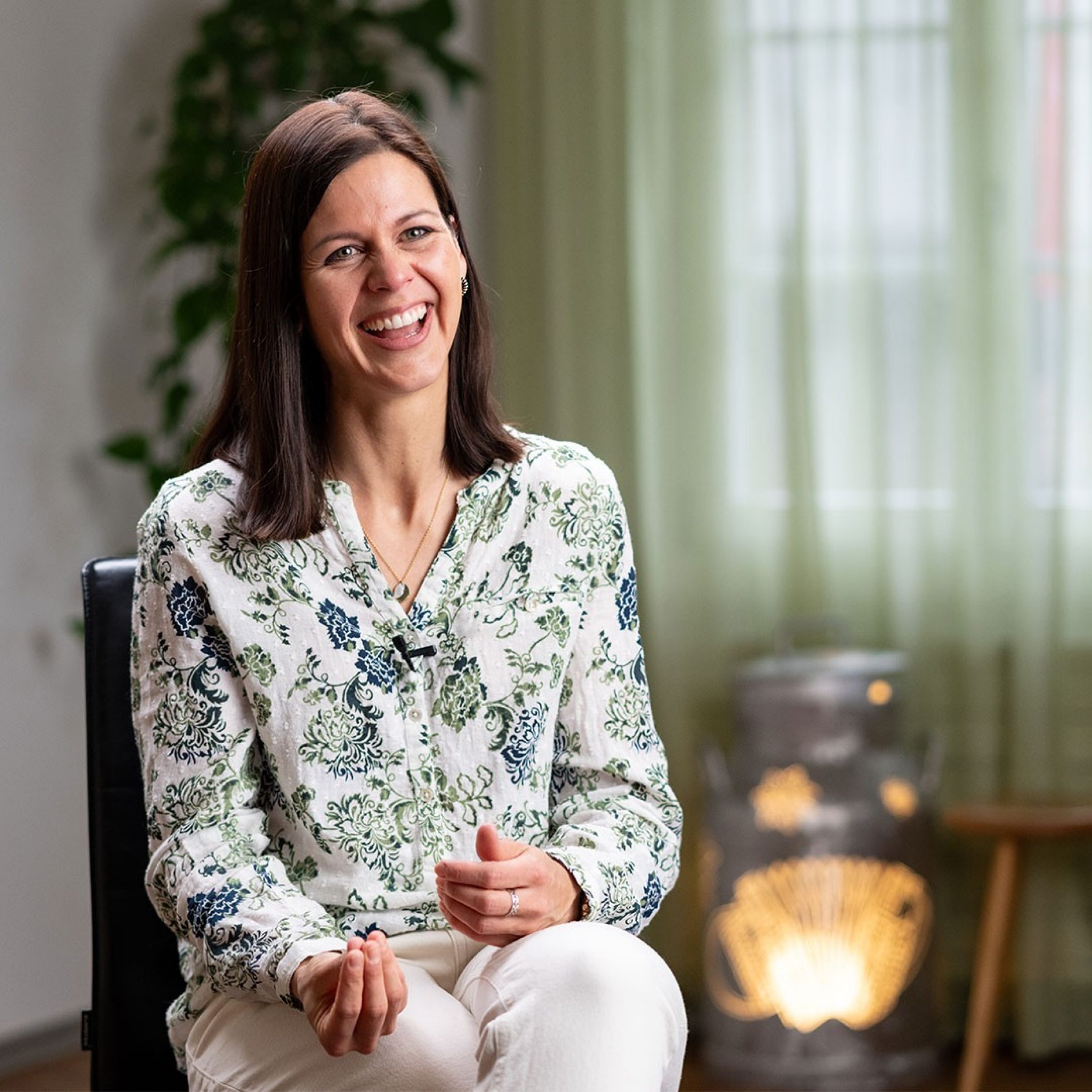 Donna seduta e sorridente in una stanza
