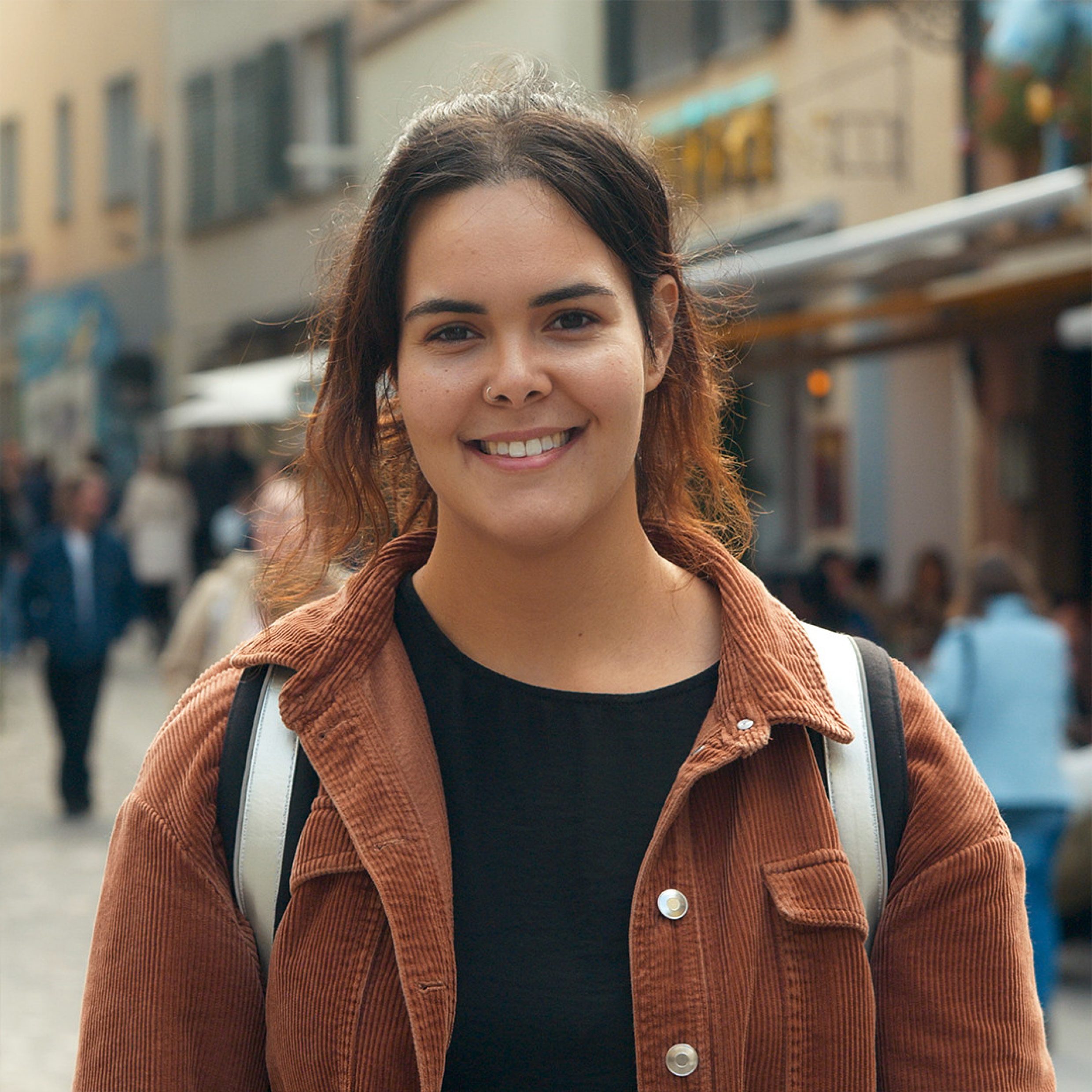 Ritratto di donna, sullo sfondo si vede il centro storico di Zurigo.