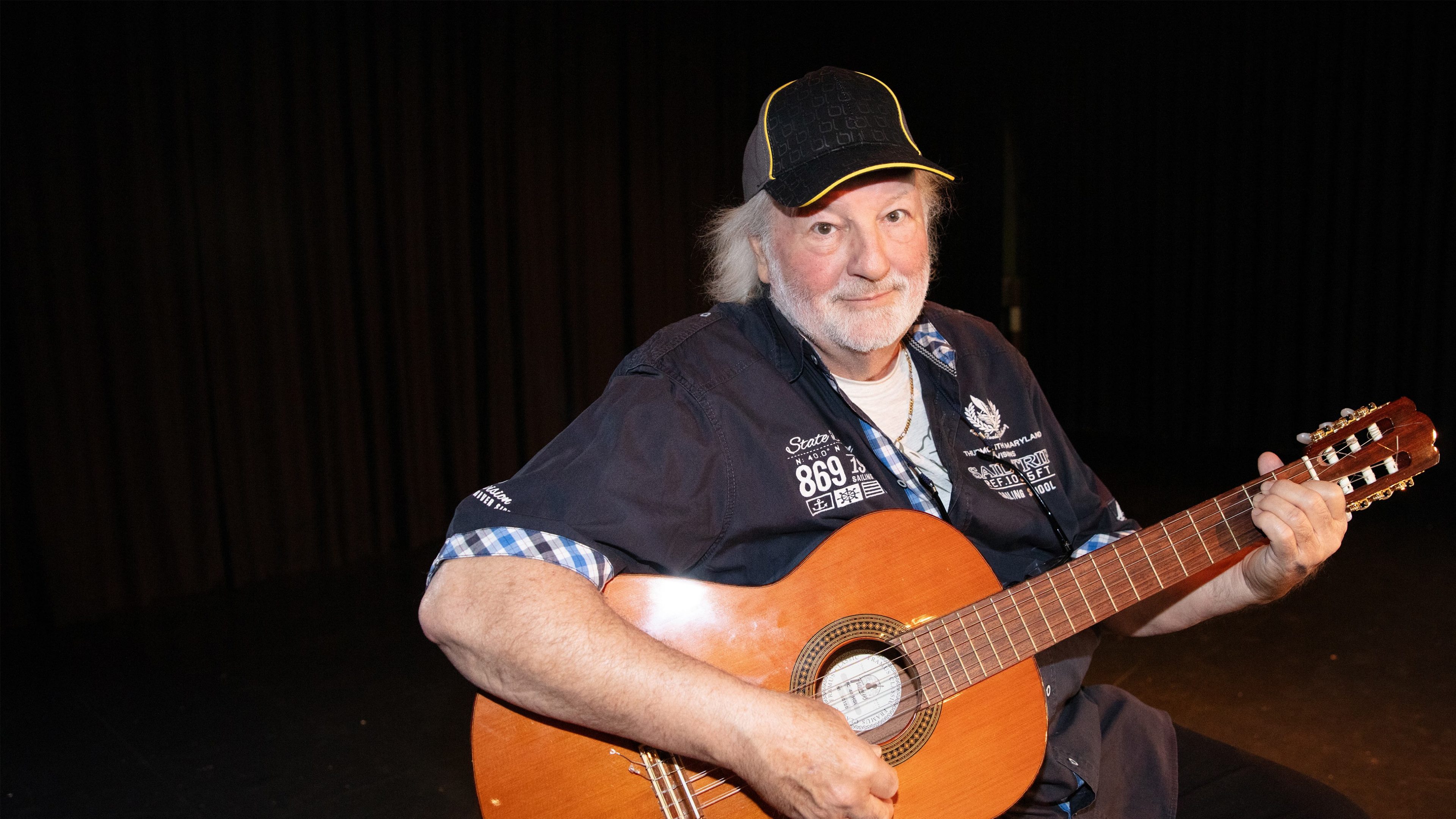 Uomo anziano e sorridente con la chitarra