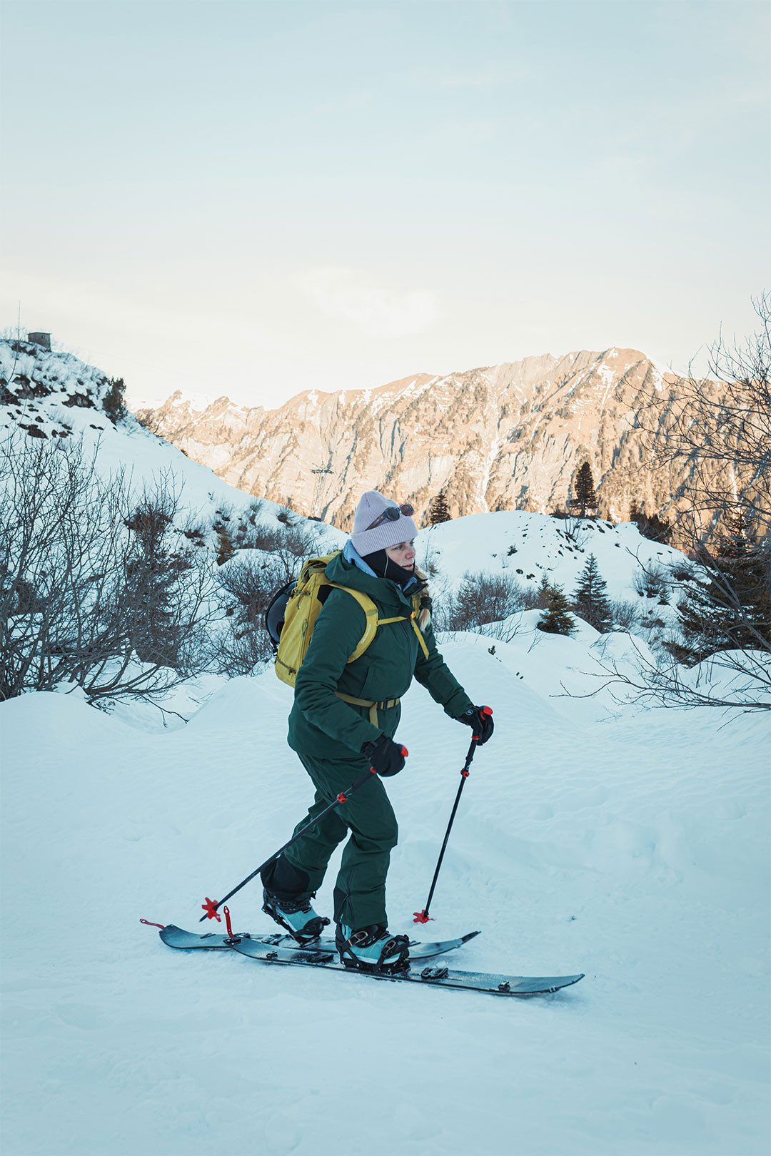 Capanna del CAS Lidernenhütte circondato da pendii alpini innevati, sullo sfondo una catena montuosa e tempo soleggiato.