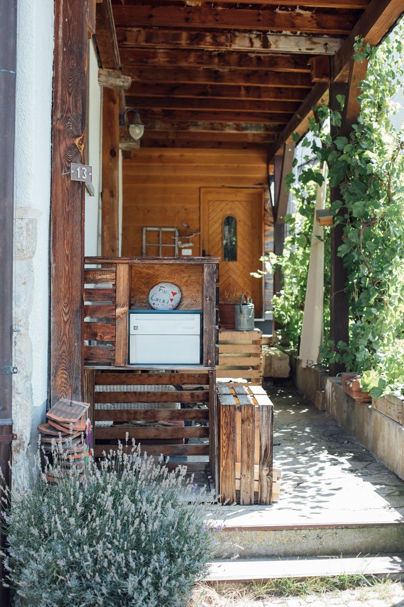 Accogliente pergolato di elementi in legno ricoperto di vegetazione.