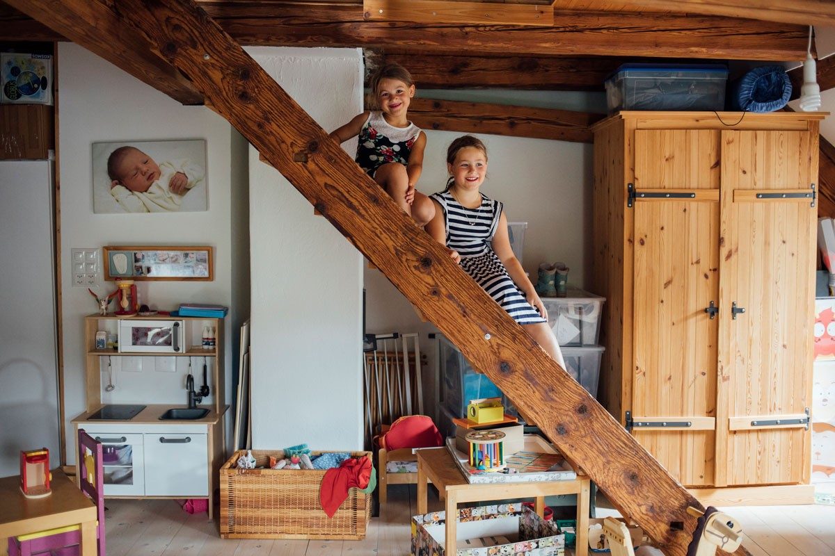 Due bambine sono sedute su una scala di legno.