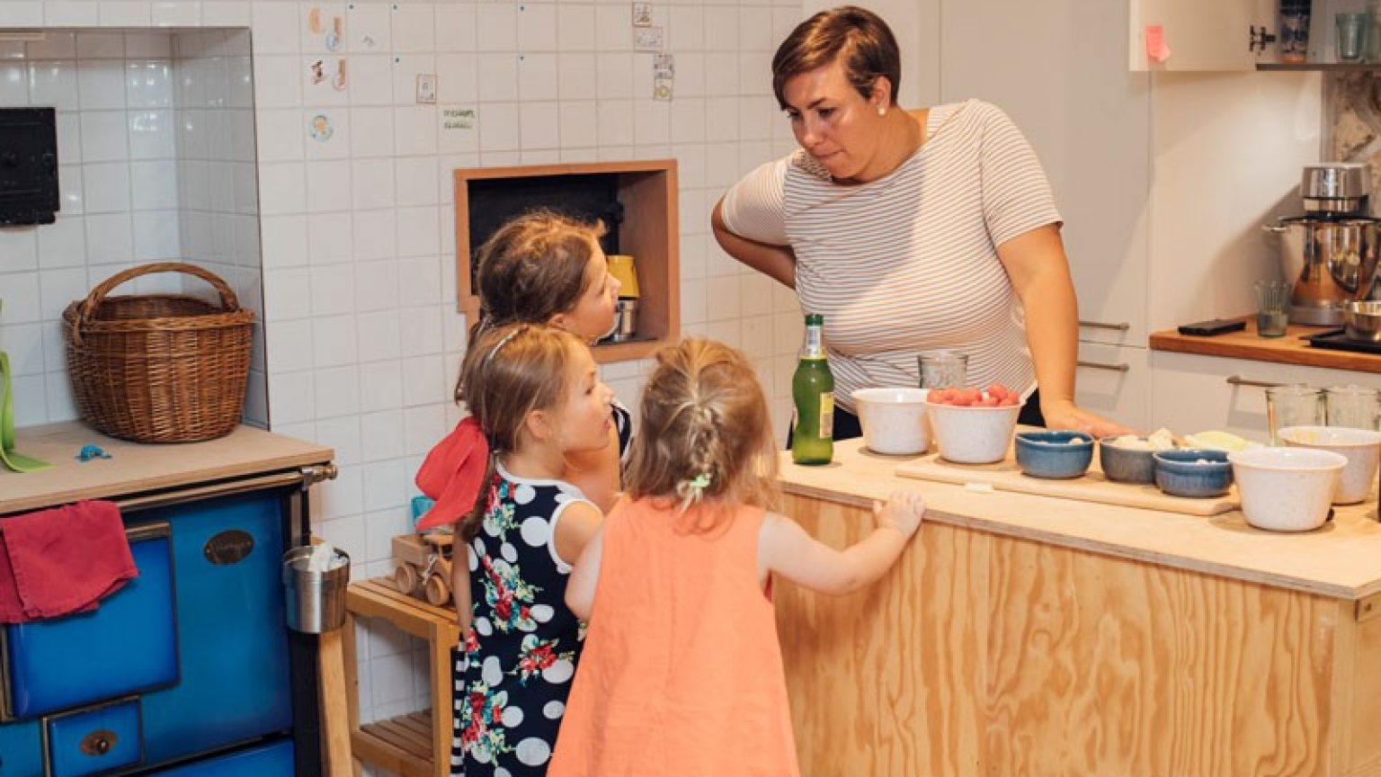 Madre con i bambini in cucina, preparano un pasto insieme.