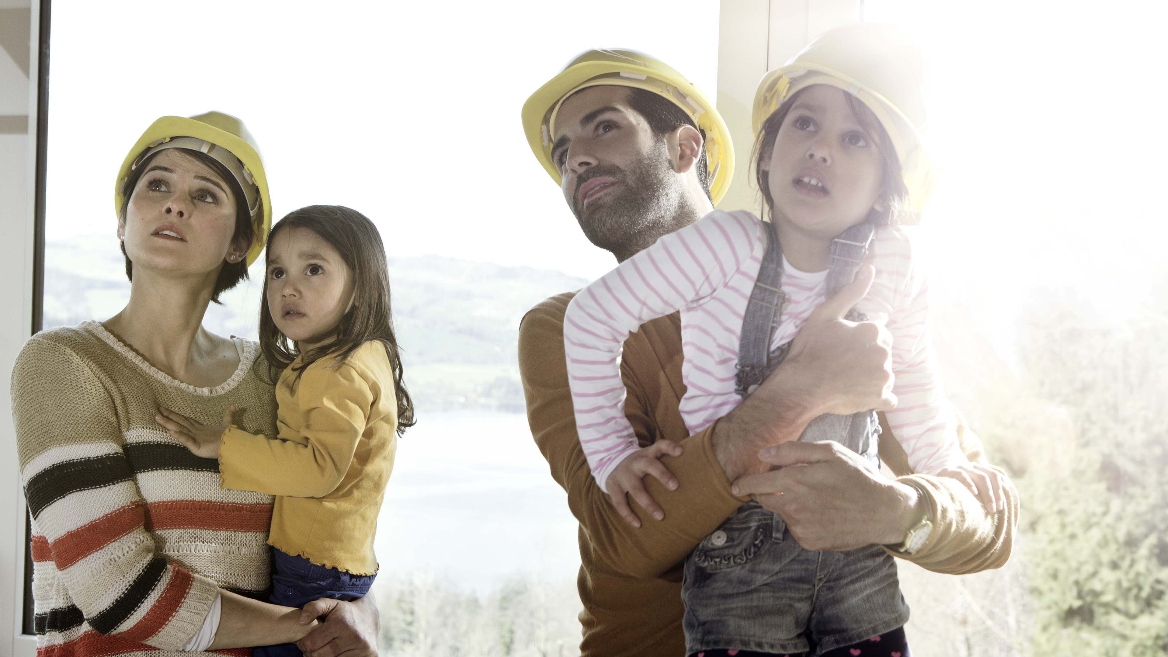 Famiglia con due bambini, adulti con cappelli gialli.