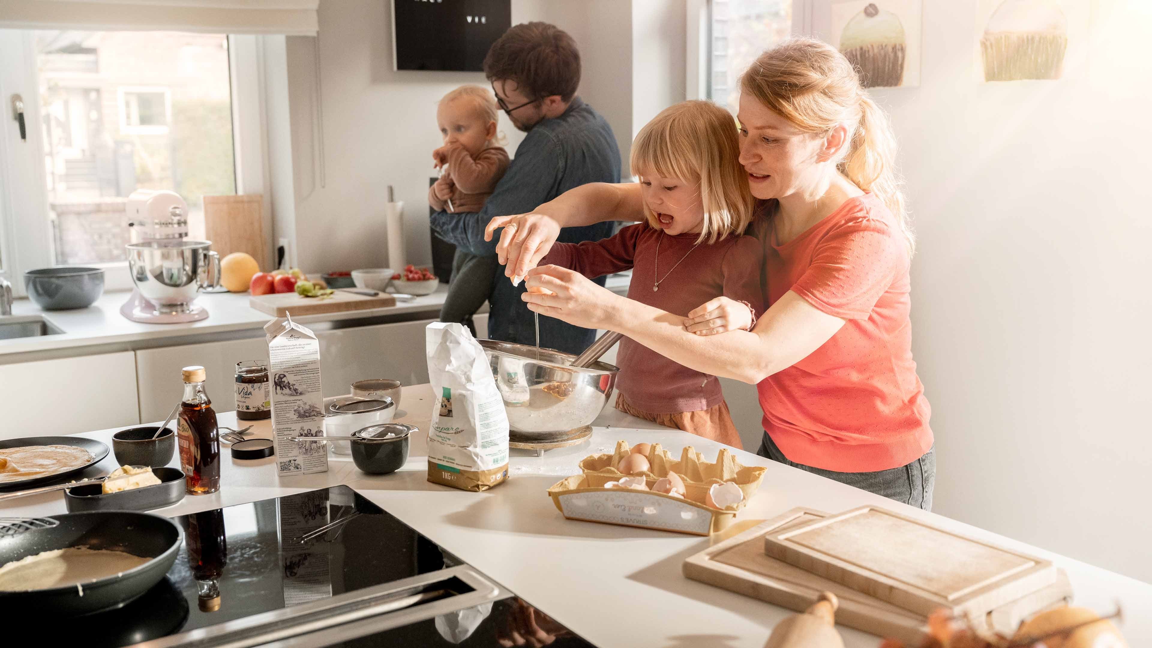Mamma e papà preparano le crêpes con i loro due figli