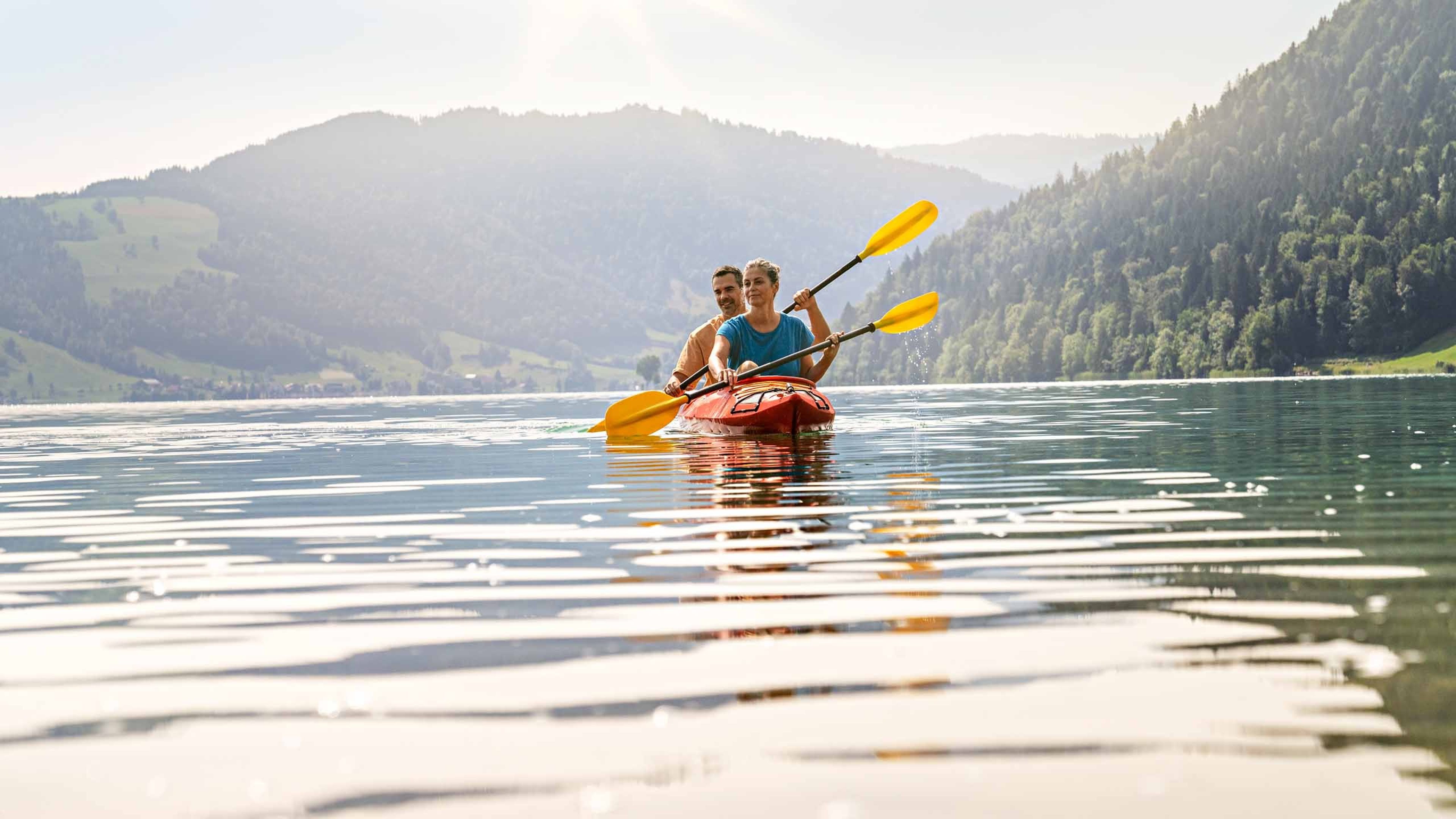 Una coppia pagaia su un lago con un kayak.