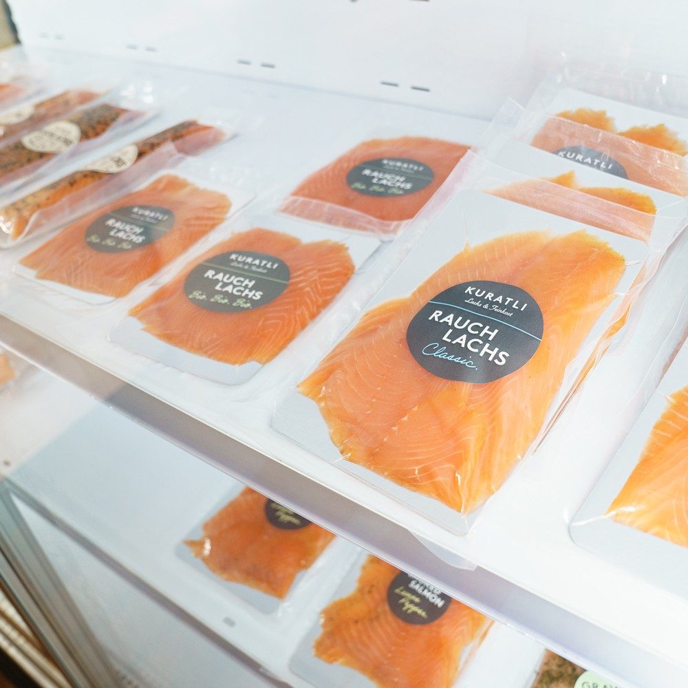 Il salmone affumicato confezionato è riposto in frigorifero. Le confezioni di salmone recano la scritta Kuratli Rauchlachs Classic.